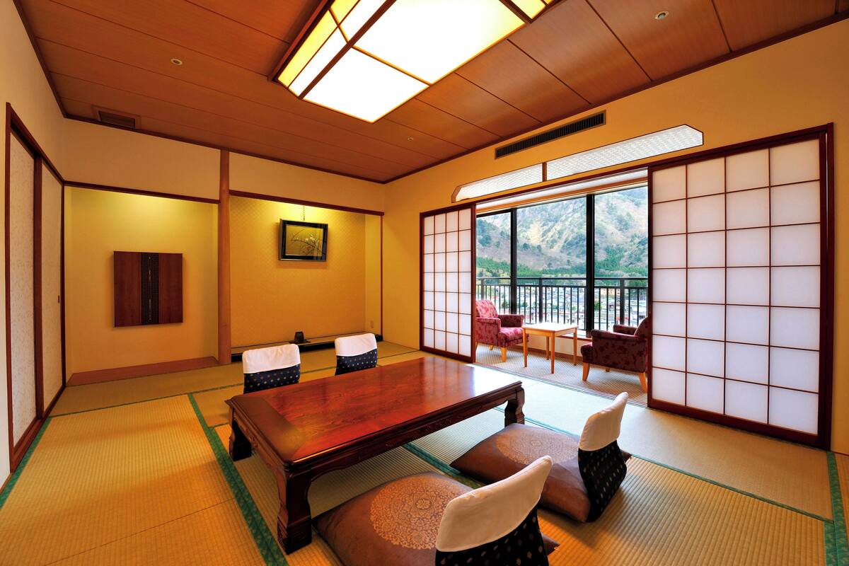 Een traditionele Japanse kamer met tatami vloerbedekking, een houten tafel en verschuifbare shoji deuren.