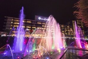 Een nachtzicht van een hotel met meerdere verdiepingen en verlichte ramen.