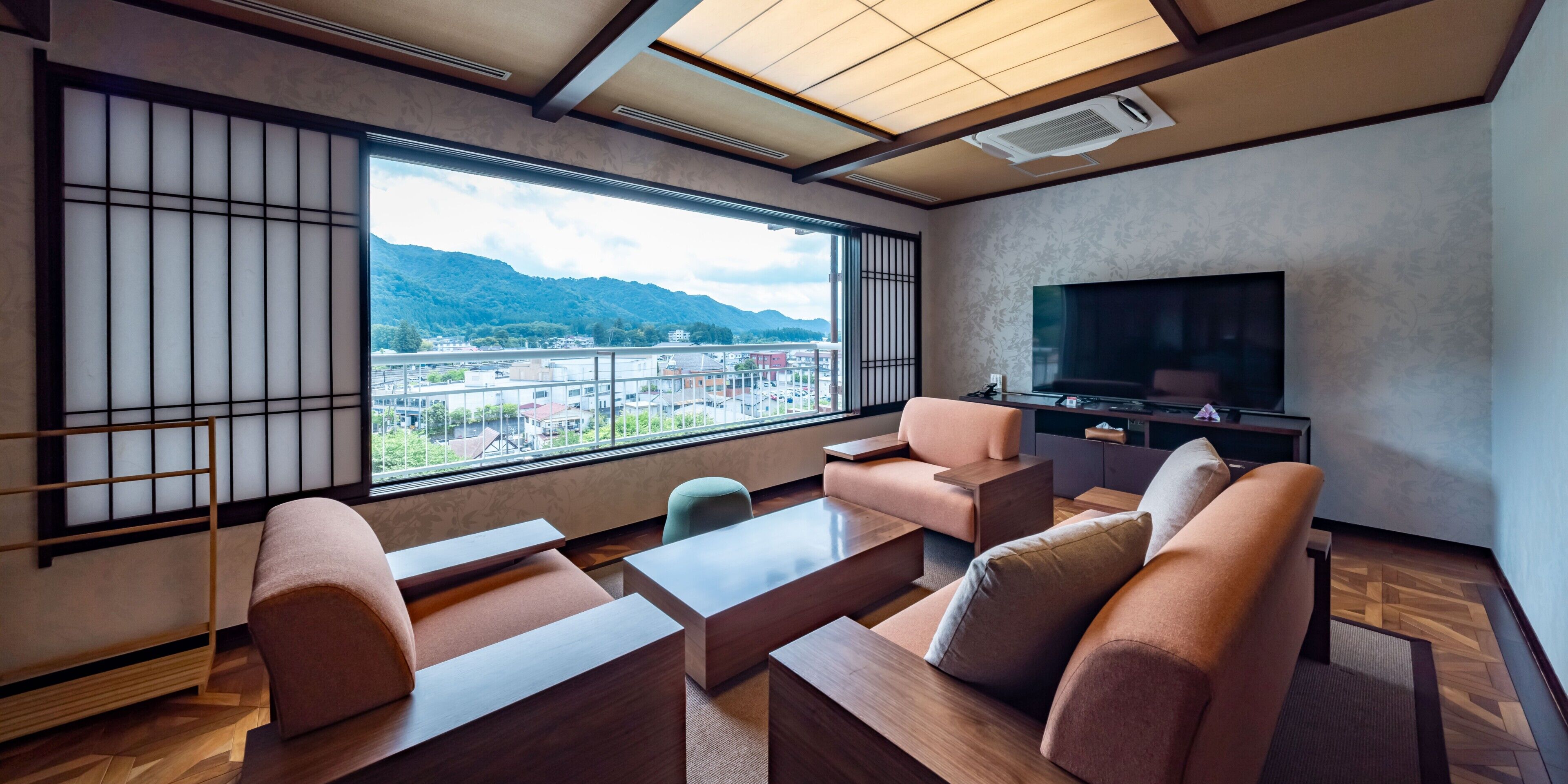 A modern living room with a large window, a flat-screen TV, and a traditional sliding door.