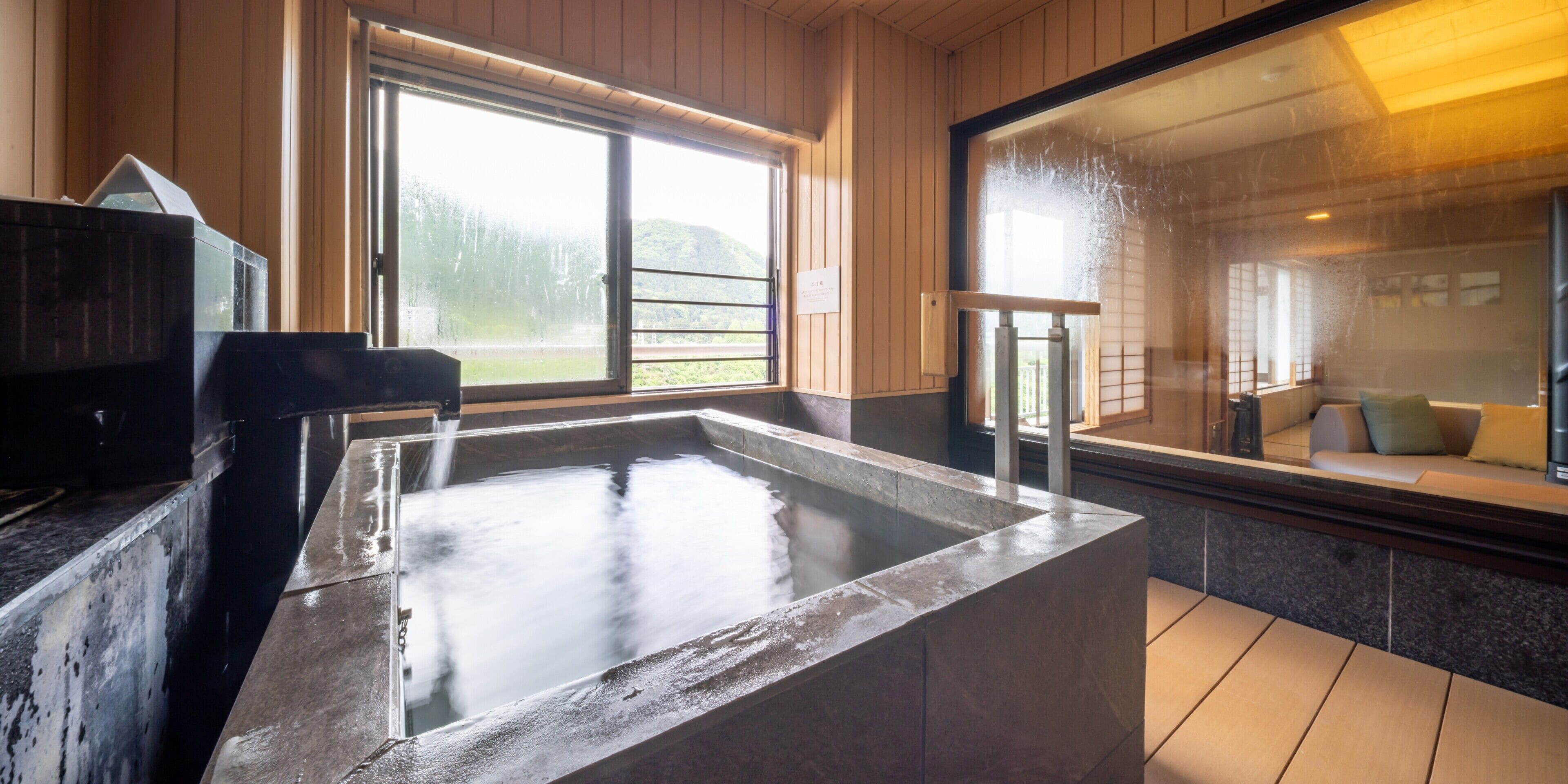A spa area with a hot tub, wooden walls, and a view of a mountain.