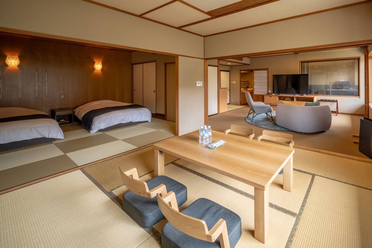 Ein traditioneller japanischer Raum mit Tatami-Böden, einem niedrigen Holztisch und einem Fernseher.