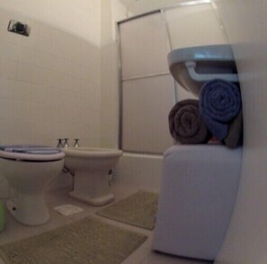 Un baño con inodoro, bidé y bañera.