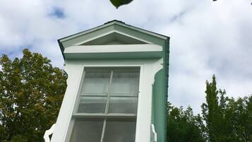 A dormer window with a white frame and a green roof.
