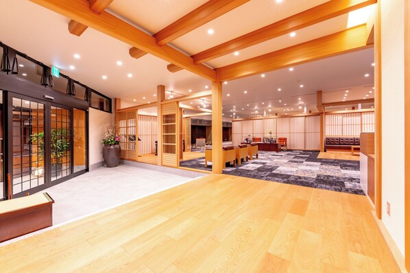 Un hall amplio con suelo de madera, una recepción, zona de estar y decoración tradicional.