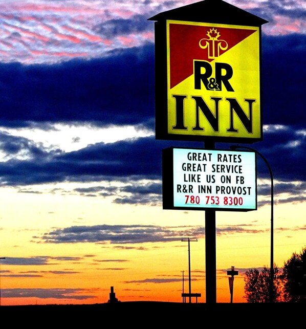 A R&R Inn sign with a sunset background.