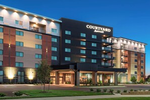 A Courtyard Marriott hotel with a modern design, featuring multiple balconies and a well-lit entrance. - Courtyard Mt. Pleasant at Central Michigan University (Mount Pleasant)