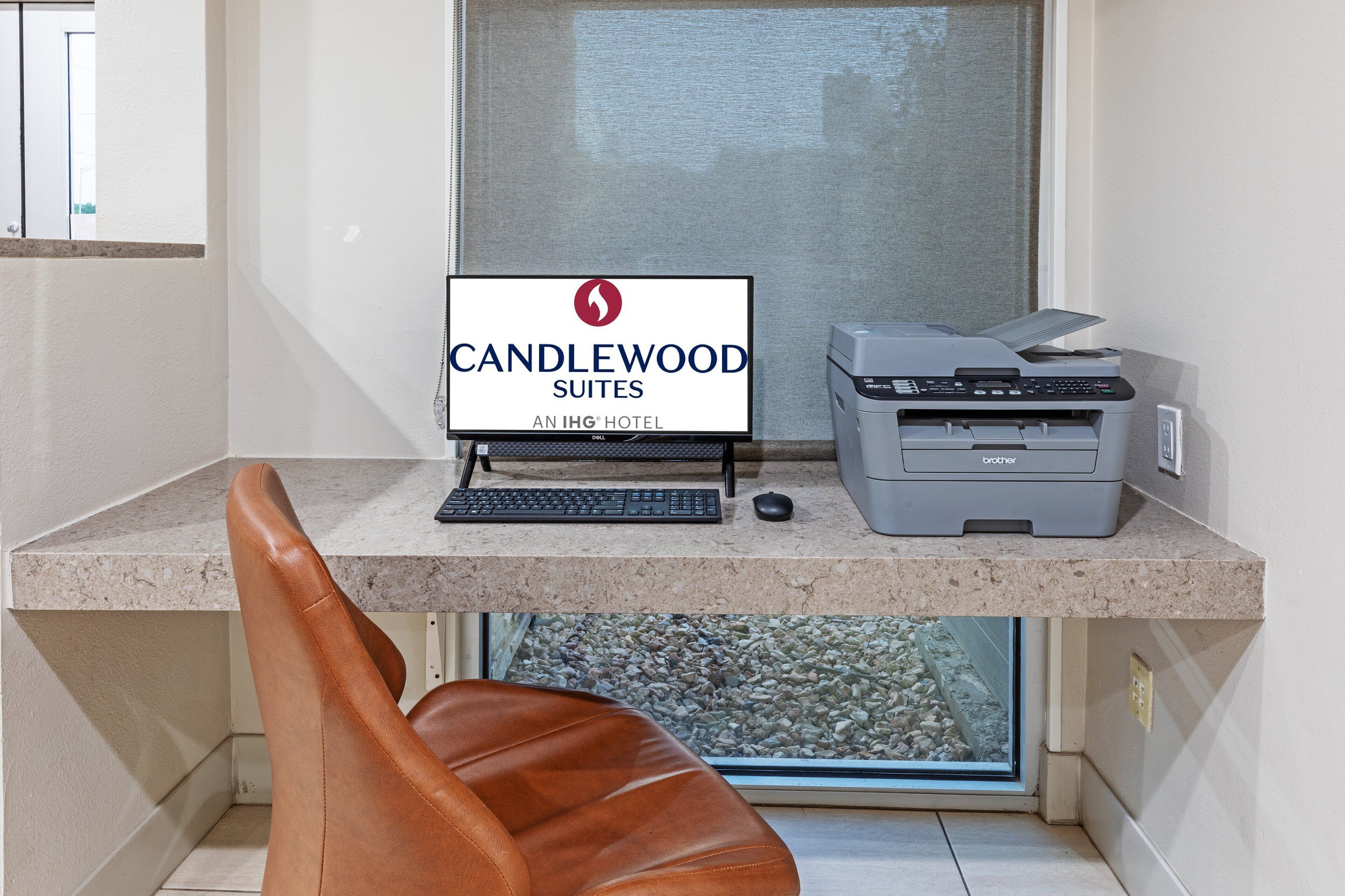 A desk with a computer, printer, and a sign for Candlewood Suites.