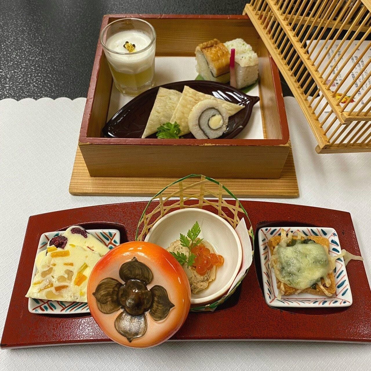 A tray with various Japanese dishes including sushi, pickled vegetables, and a small bowl of soup.