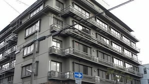 Un edificio de varios pisos con balcones y una señal de paso de peatones.