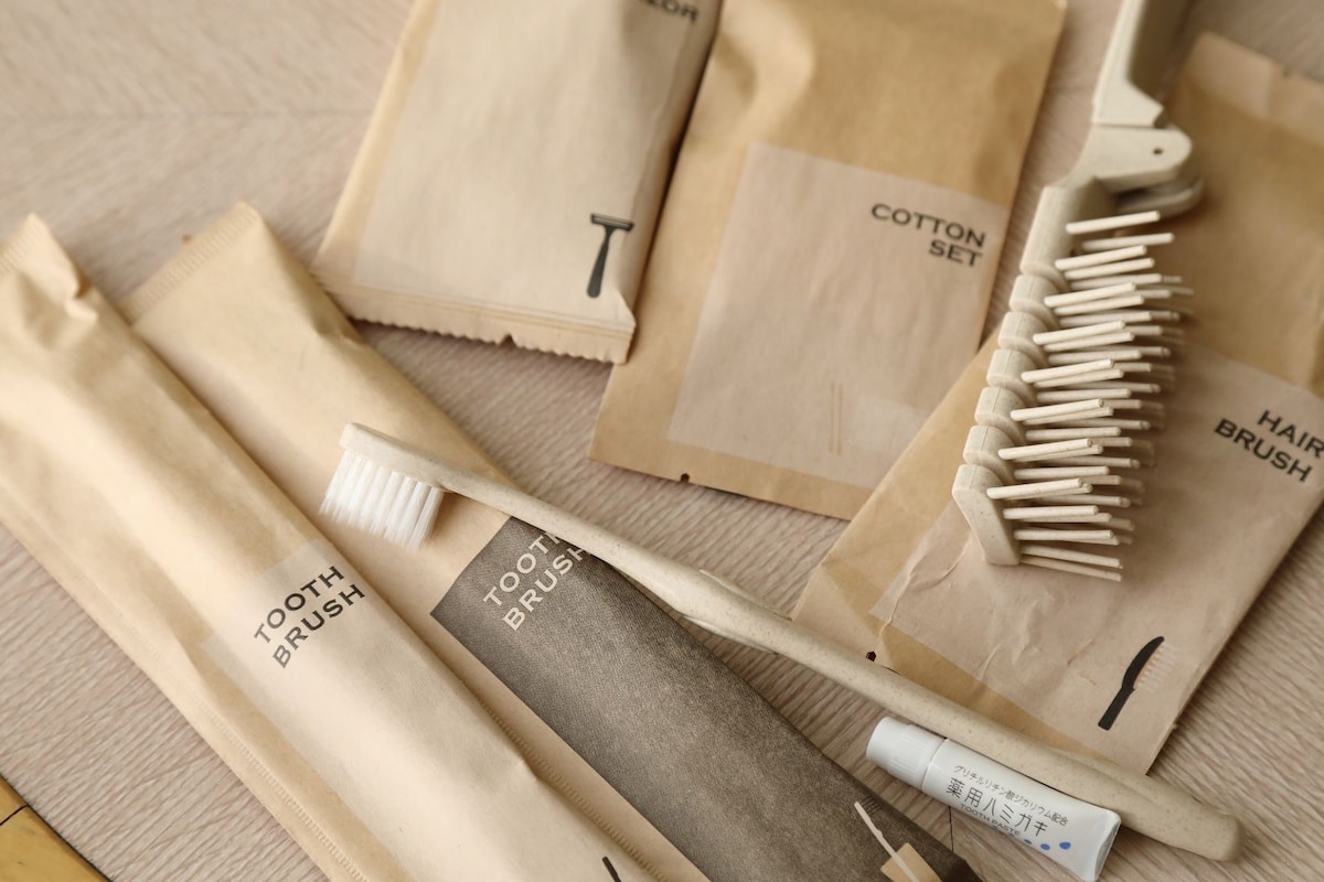 A collection of personal care items including a toothbrush, a hairbrush, and cotton set packages.