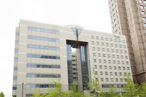 A modern hotel building with a prominent entrance, multiple floors, and a clear view of the interior through the windows. - Seaside Hotel Twins Momochi (Fukuoka)