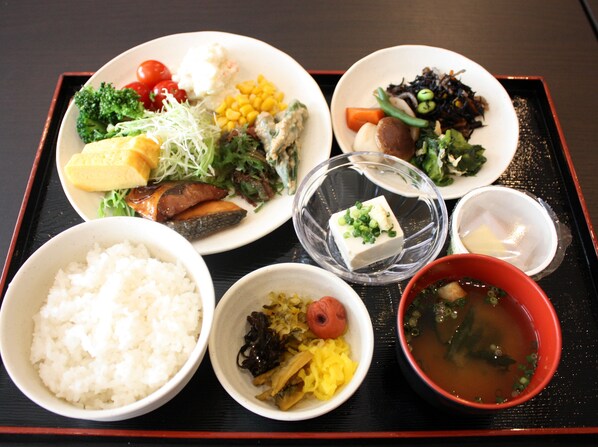 Una bandeja con varios platos, incluyendo arroz, tofu, verduras y sopa.