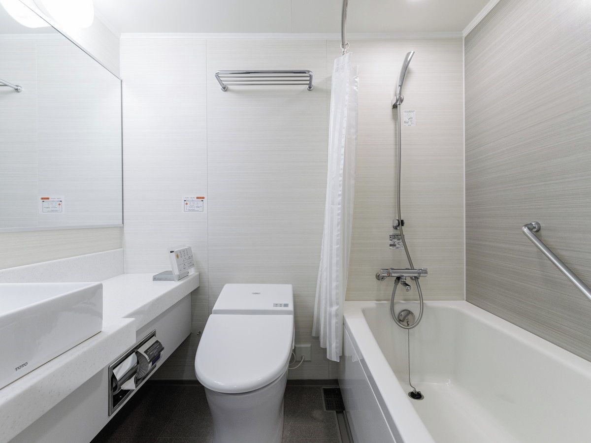 Une salle de bain moderne équipée de toilettes, d’un lavabo et d’une baignoire.