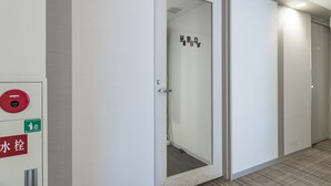 Ein Flur mit einer Tür zu einem Zimmer, einem Rauchmelder und einem Schild für Wasserausfall.