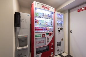 En försäljningsautomat med en Coca-Cola-logotyp, en Kirin-automat och en vattenautomat.