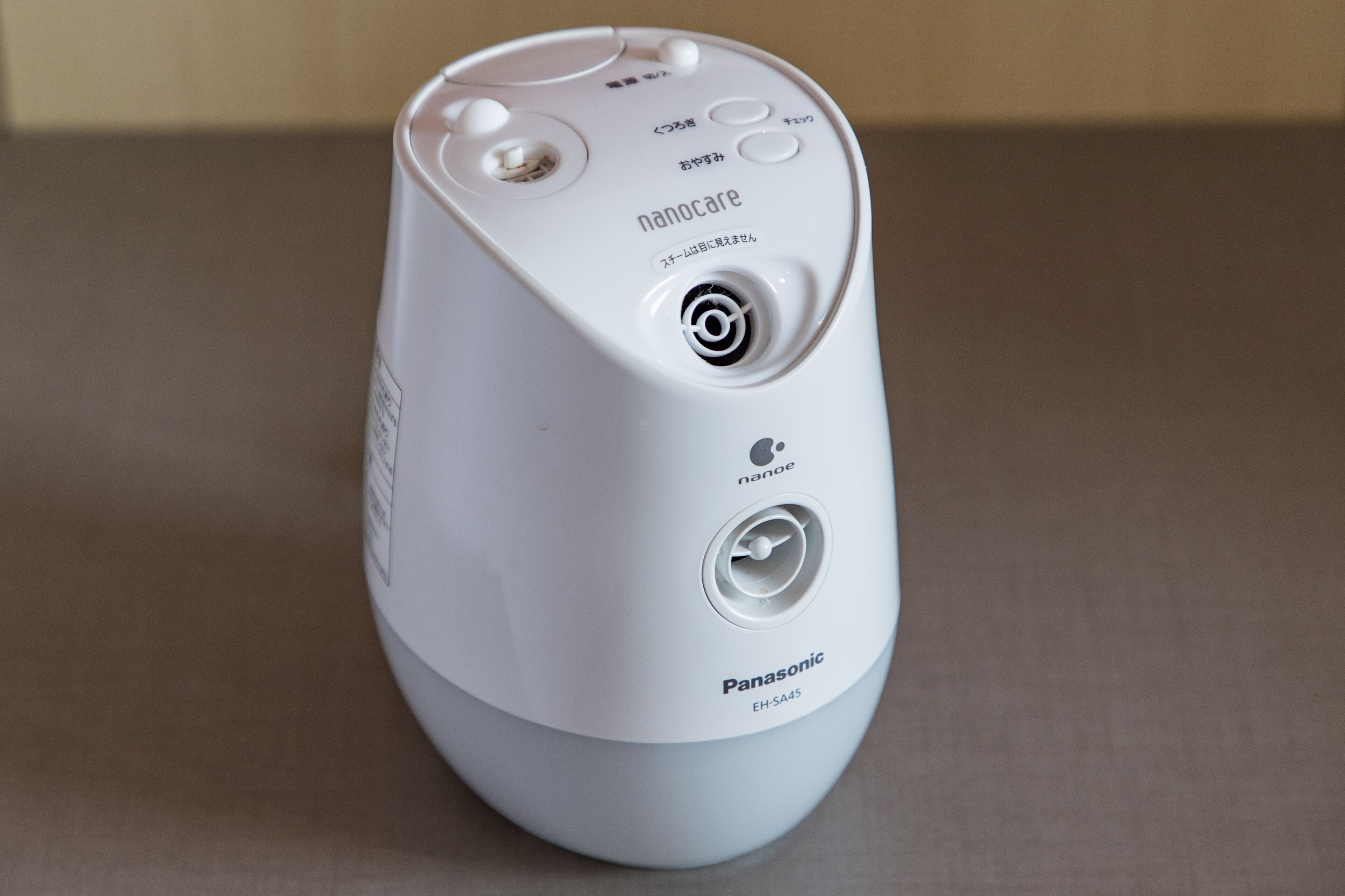 Un dispositivo Panasonic EH-SA45 blanco con un botón circular, una pantalla pequeña y un puerto de carga.