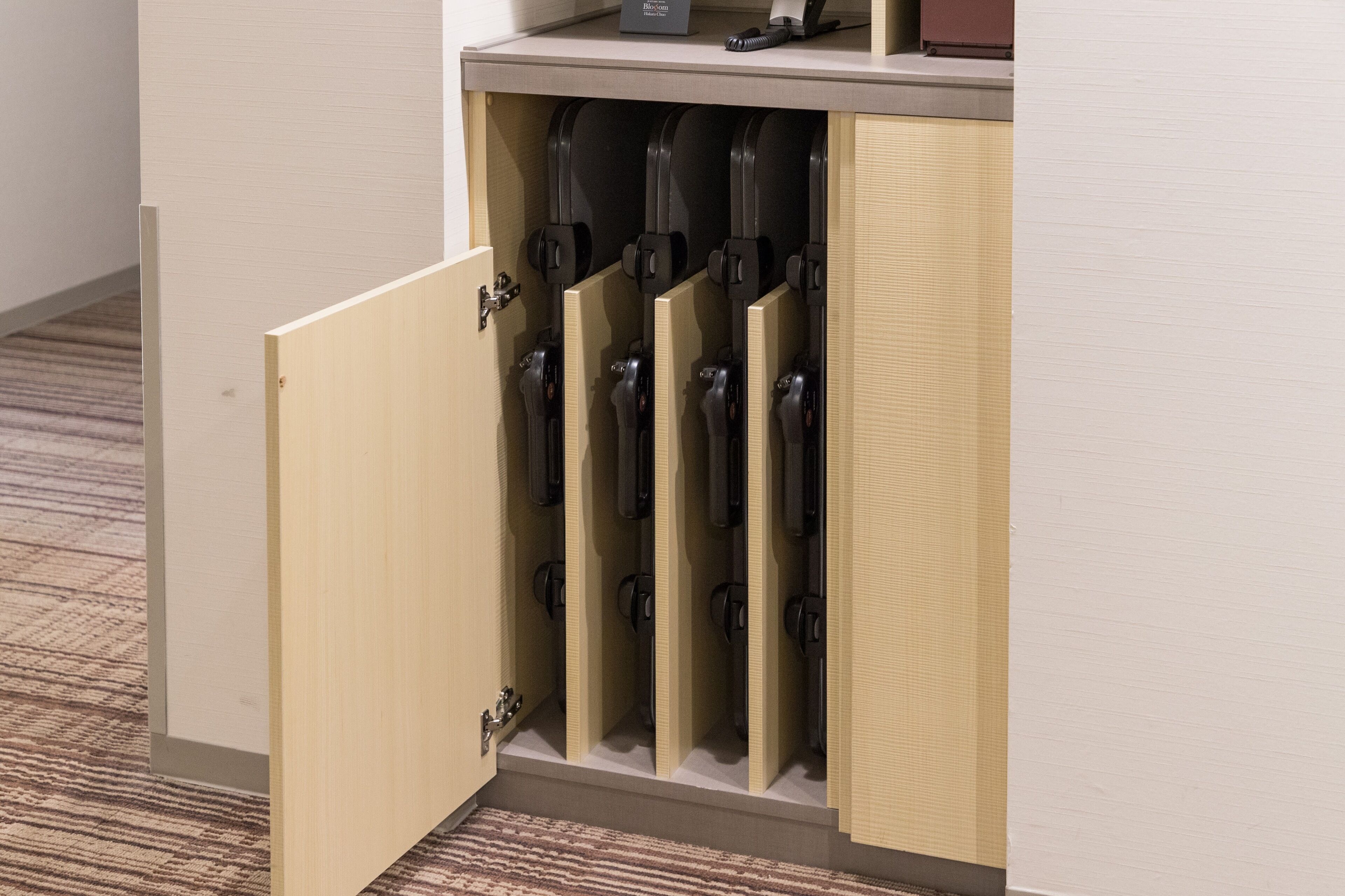 Un baño con un mueble de madera que alberga varios orinales.