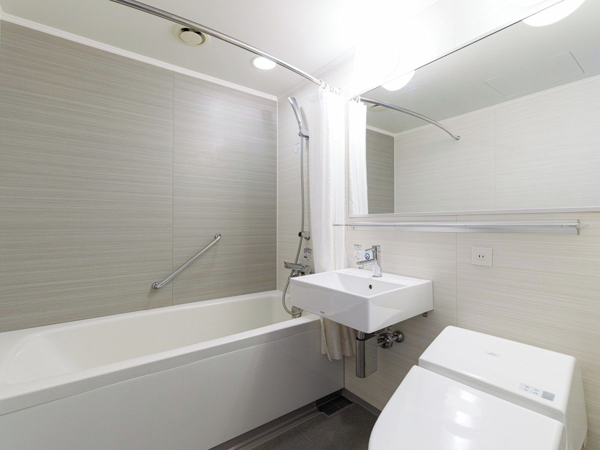 A modern bathroom with a bathtub, a sink, and a toilet.