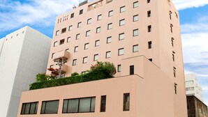 A multi-story building with a flat facade, numerous windows, and a rooftop garden. - Kochi Sunrise Hotel (Kochi)