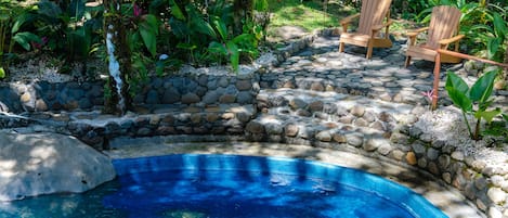 Una piscina al aire libre, sillones reclinables de piscina