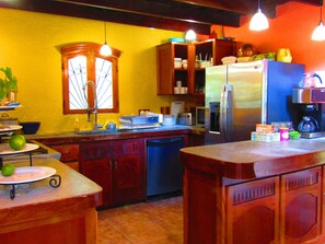 A kitchen with wooden cabinets, a stainless steel refrigerator, and a sink.