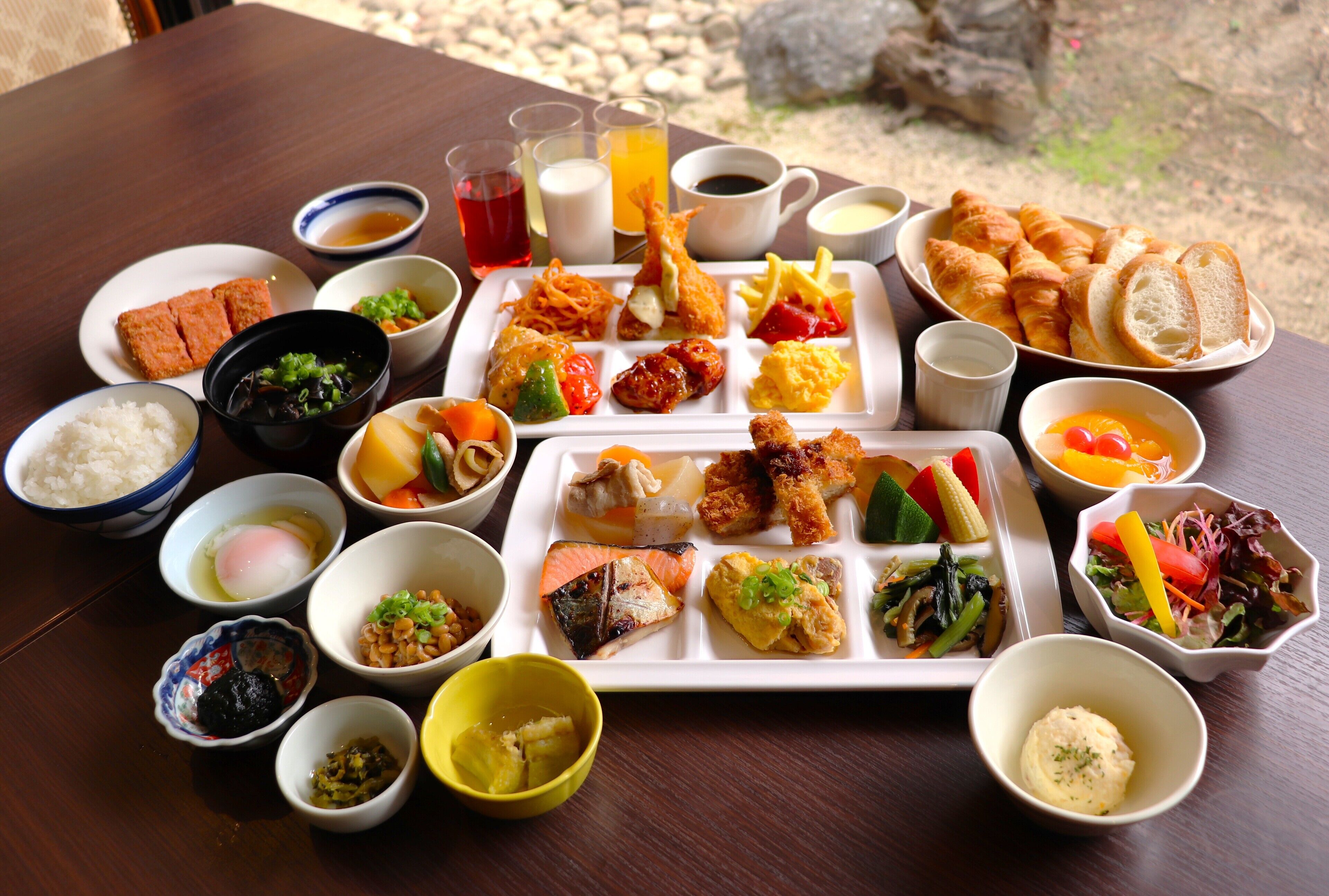 Diversos platos y bebidas sobre una mesa de madera, indicando un ambiente para comer.