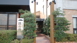 Uma trilha que leva a um edifício com uma placa em japonês.