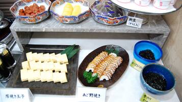 A buffet with various dishes including tofu, sashimi, and pickled vegetables.