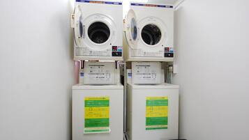 Two stacked washing machines in a laundry room.