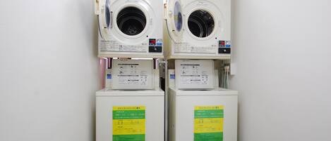 Two stacked washing machines in a laundry room.
