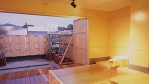 Un jacuzzi de madera en una habitación con vista a edificios.