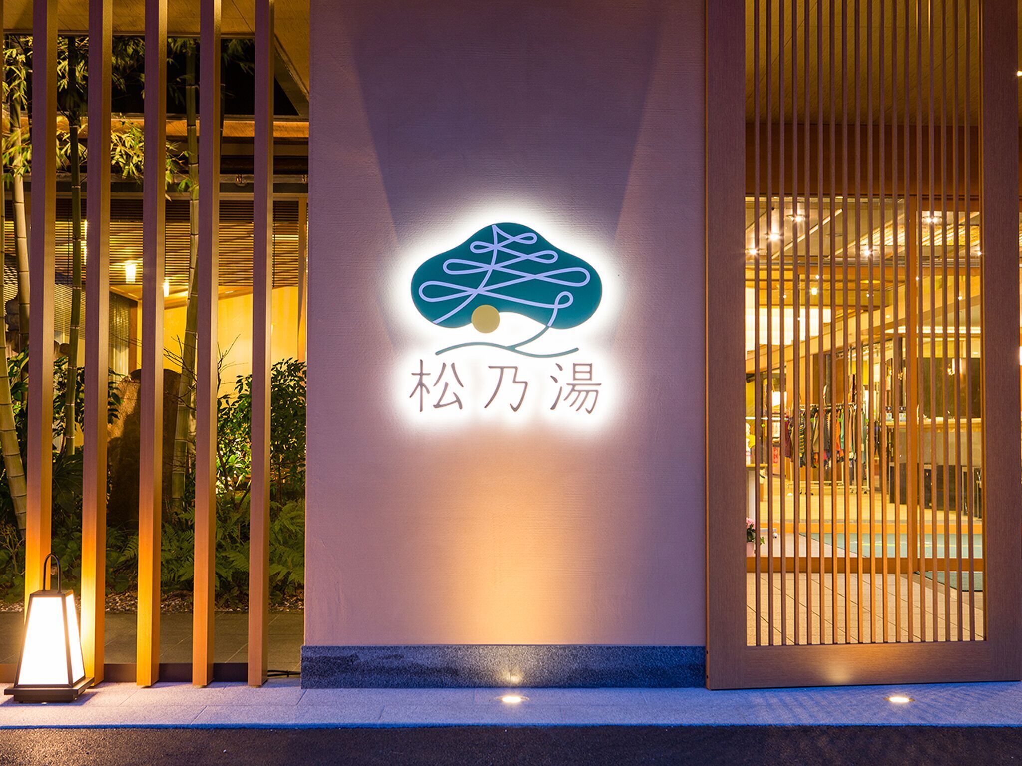 A building entrance with a neon sign displaying a logo and Chinese characters.