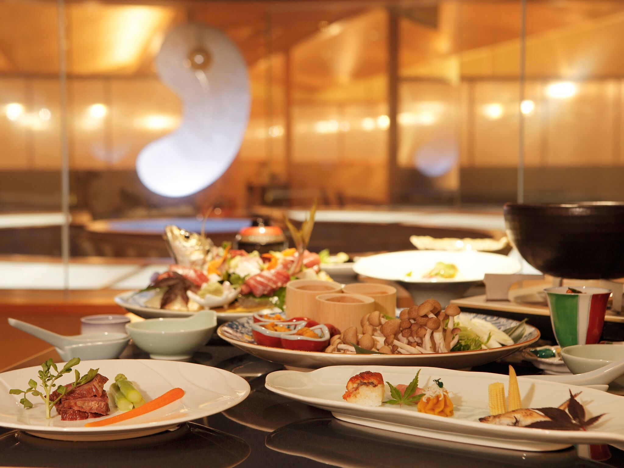 A dining table with various dishes, including meat, vegetables, and a bowl of mushrooms.