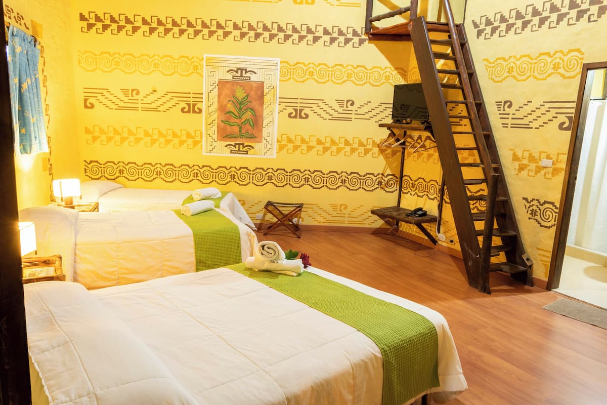 Ett hotellrum med två sängar, en trästege, en vägg med geometriska mönster och en inramad tavla.