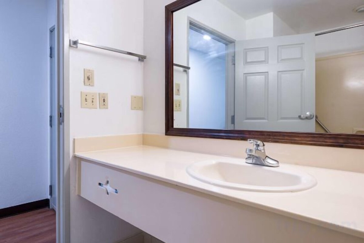 A bathroom with a white sink, a mirror, and a towel rack.