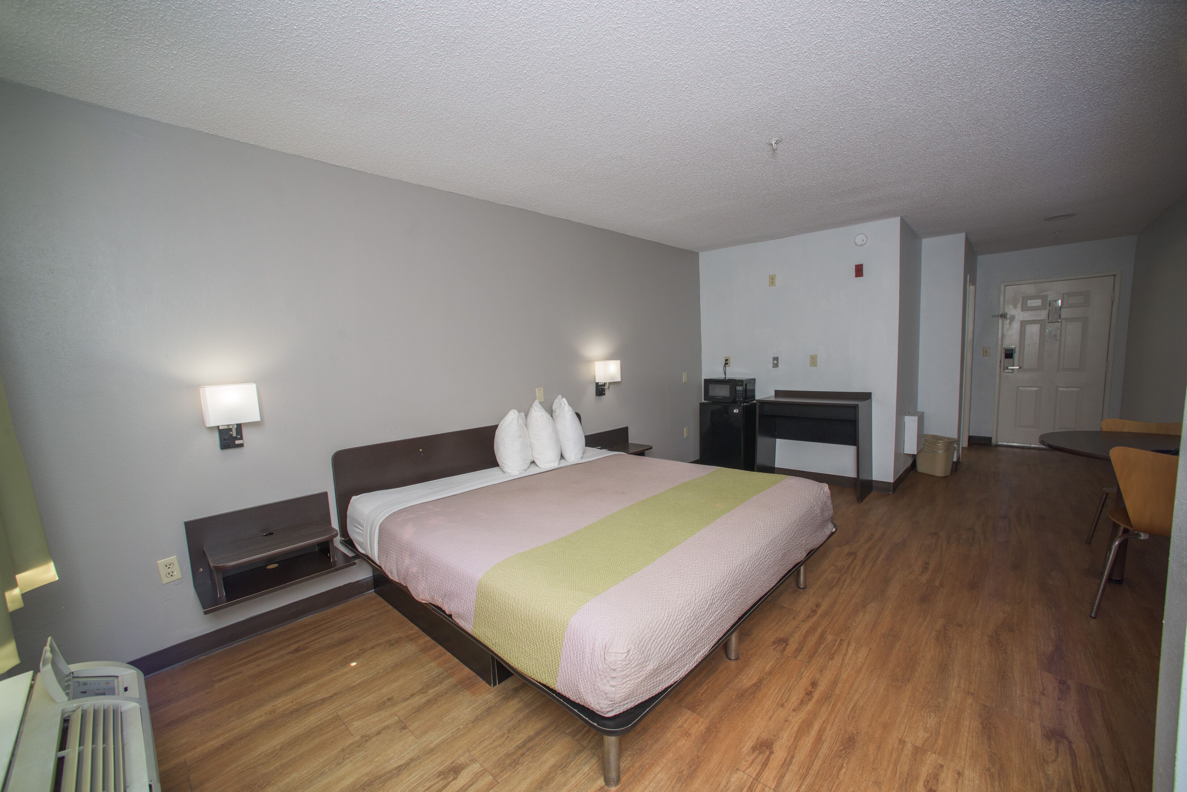 Une chambre d’hôtel comprenant un lit, des tables de chevet, un bureau et une chaise.