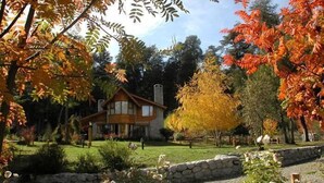 Una casa rodeada de un jardín con follaje otoñal.