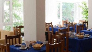 A dining area with tables set for breakfast, featuring wooden chairs and blue tablecloths. - Posta del Viajante (Mar del Plata)