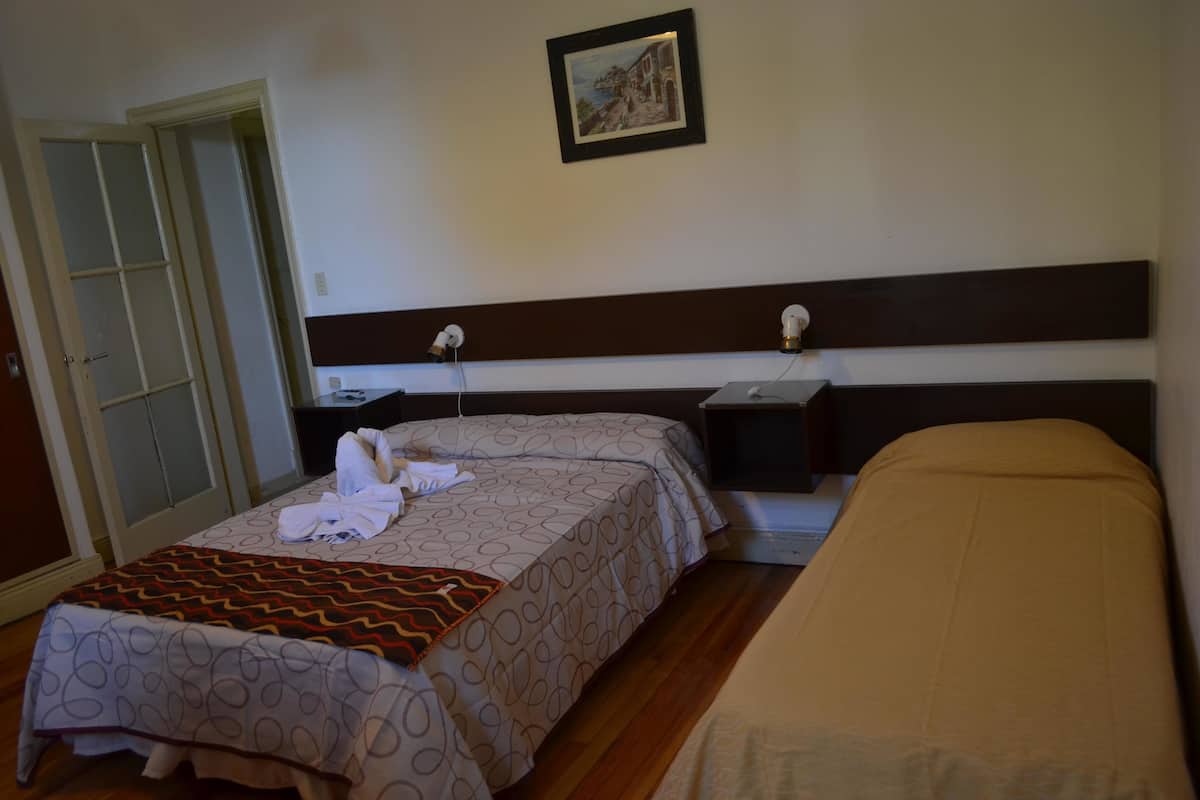 Ein Hotelzimmer mit einem Bett, einem Nachttisch und einem Kleiderschrank.
