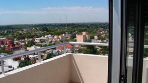 Un balcon donnant sur un quartier résidentiel, avec vue sur les maisons et la végétation.