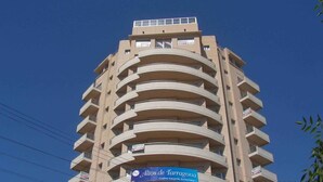Un immeuble à plusieurs étages, doté de balcons et d’une enseigne indiquant « Altos de Tarragona ».