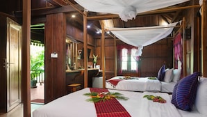 Une chambre avec deux lits, des murs en bois, un lit à baldaquin et une vue sur l’extérieur.