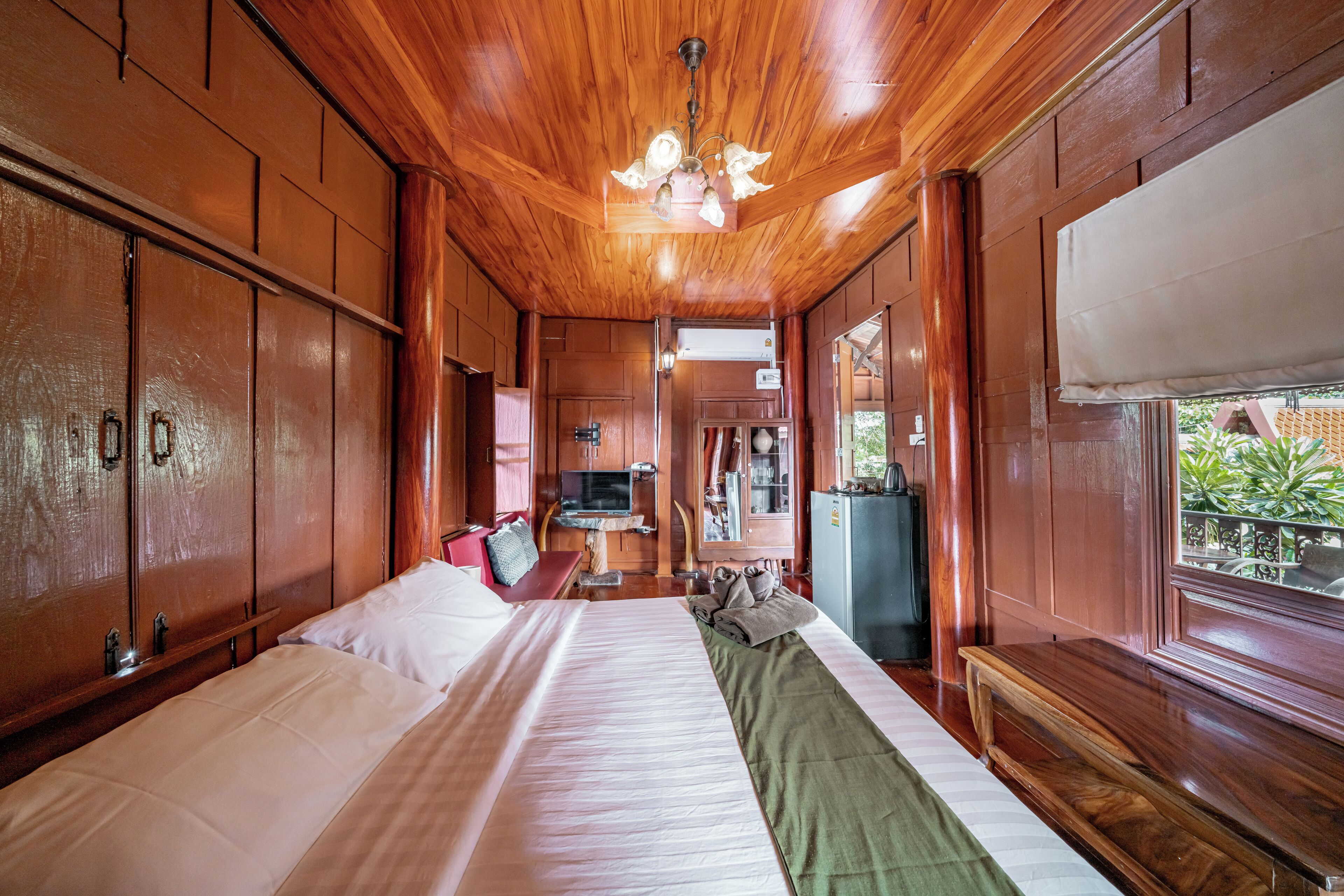 Ein holzgetäfeltes Zimmer im Blockhausstil mit einem großen Bett, einem Schreibtisch und einem Fernseher.