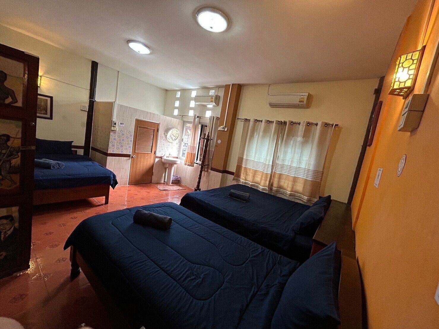 Een hotelkamer met twee bedden, een badkamer en een klein zithoekje.