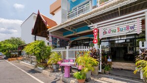 A guesthouse with a white picket fence, potted plants, and a signboard. - Bann One Love (Ayutthaya)