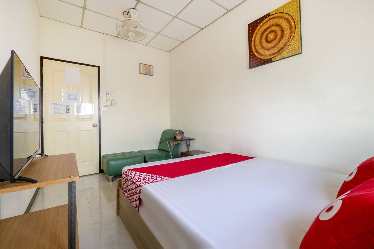 Une chambre d’hôtel comprenant un lit, un bureau, une chaise, une petite table et un téléviseur.
