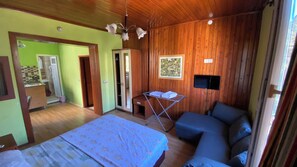 A bedroom with a bed, a sofa, a TV, and a drying rack. - Camel Apart (Antalya)