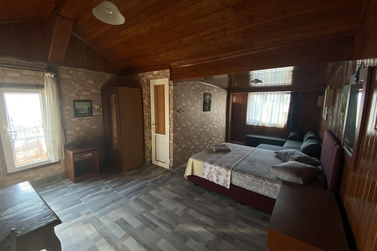 Una habitación con cama, escritorio y ventana.