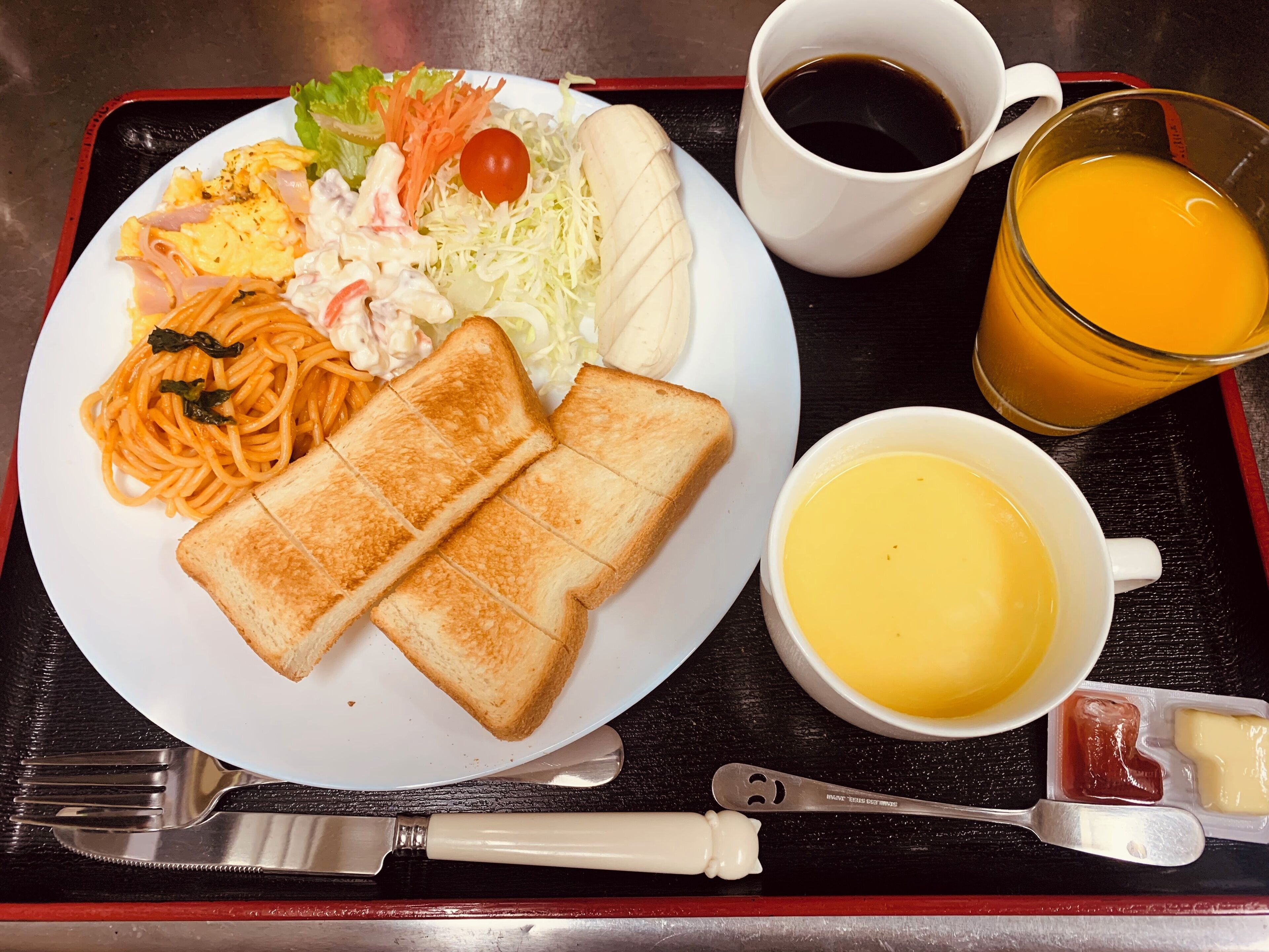 A tray with a plate of food including toast, spaghetti, salad, and a cup of coffee.