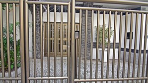 A gated entrance with a metal fence, a stone wall, and a door. - Rio Spot Apartment C019 (Rio de Janeiro)